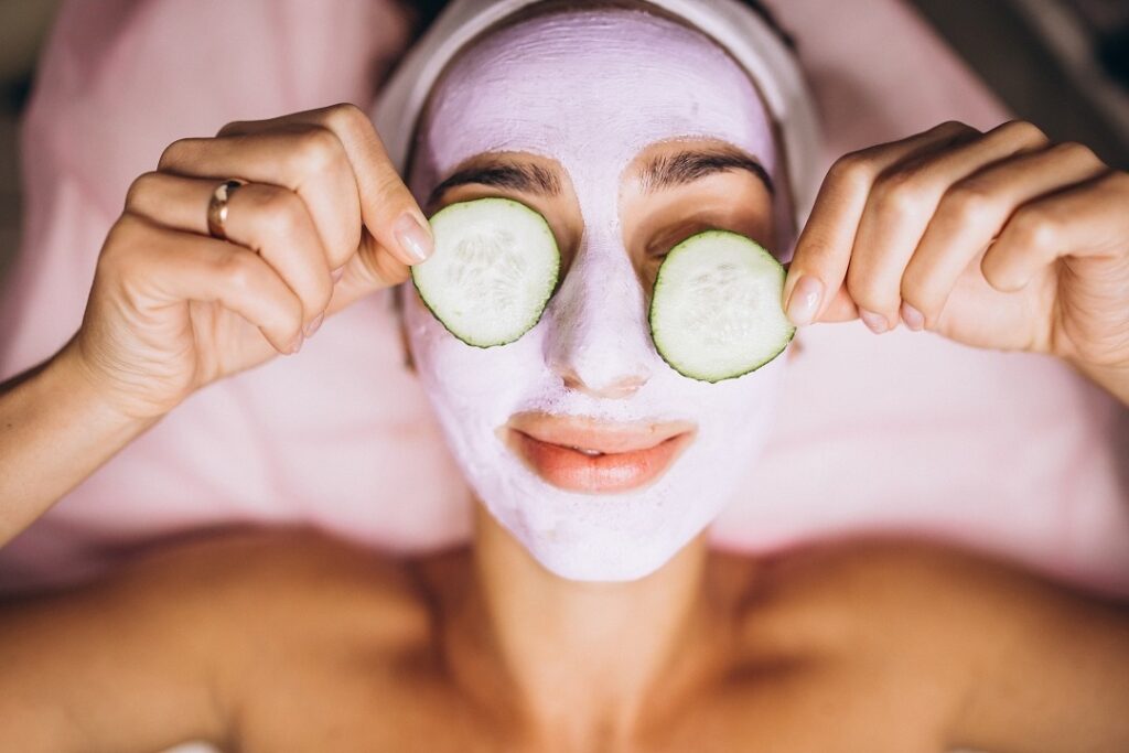 Woman Facial with mask and cucumber on her eyes